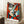 May include: Framed geometric abstract portrait poster in Picasso-inspired cubist style featuring a fragmented face with bold red, orange, teal, and cream color blocks. The artwork shows angular facial features with one prominent eye and curved lips. Frame leans against white wall next to beige sofa, with coffee cup on wooden side table and soft natural lighting creating window shadows on the wall.