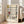 May include: Framed art print featuring geometric abstract design with black grid lines and colored rectangles in yellow, red, and blue on cream background. Shows artist name "PIET MONDRIAN" and dates "1872-1944 Trafalgar Square" below artwork. Light wood frame leaning against white wall next to beige upholstered sofa in bright, naturally lit room with hardwood floors.