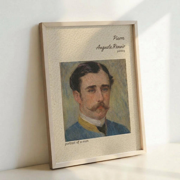 May include: Framed vintage-style poster print featuring a painted portrait of a mustachioed man in blue military uniform with yellow collar details. The artwork shows impressionistic brushwork with warm skin tones against a muted background. Text reads "Pierre Auguste Renoir painting" and "portrait of a man" on cream-colored paper. Light wood frame displayed leaning against white wall on white surface with soft natural lighting.