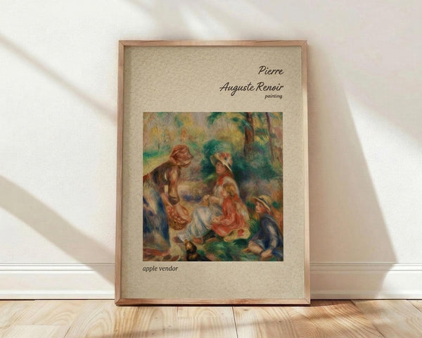 May include: Framed art print of Renoir's impressionist painting showing women and children in a pastoral outdoor scene with warm earth tones and soft brushstrokes, displayed in thin wooden frame against white wall on light wooden floor with natural window lighting creating diagonal shadows