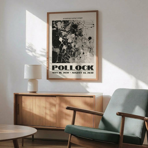 May include: Abstract black and white art poster with splattered paint design in wooden frame, displayed above mid-century modern wooden sideboard with ceramic lamp. Sage green upholstered chair with wooden arms sits nearby on hardwood floor with natural sunlight streaming across white walls.