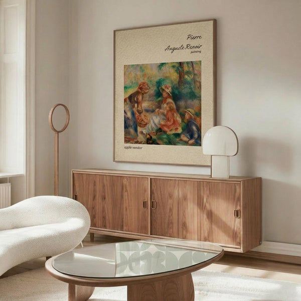 May include: Framed art print featuring Impressionist painting of two figures in warm oranges, greens and blues displayed above a mid-century modern wooden credenza with sliding doors. White sculptural chair and glass-top oval coffee table visible in foreground. Minimalist room with neutral walls and natural lighting from window.