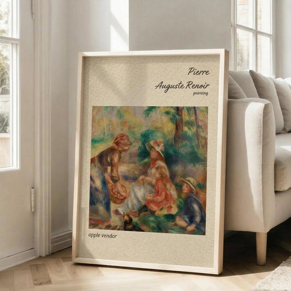 May include: Framed poster print of a Renoir impressionist painting showing figures in an outdoor garden setting with soft brushstrokes in warm oranges, greens, and blues. The artwork is displayed in a light wooden frame against a textured beige mat, leaning against a white wall next to a cream-colored armchair near tall windows with natural lighting.