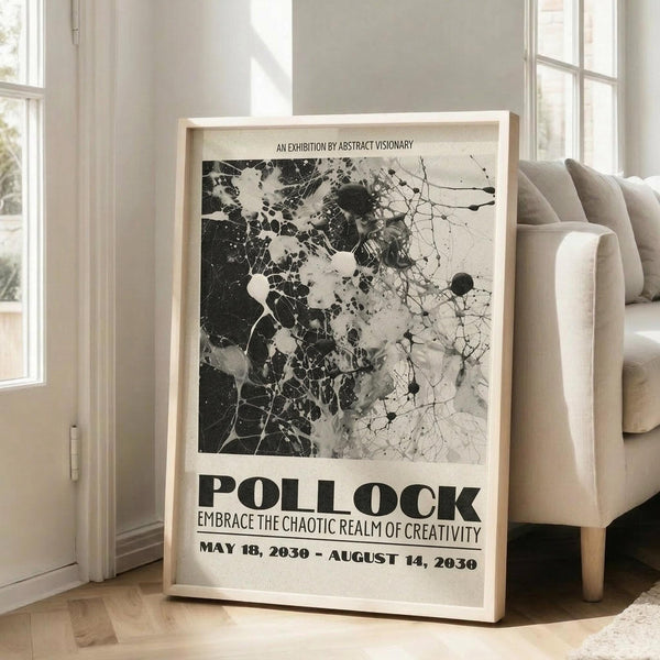 May include: A framed abstract art exhibition poster featuring black and white paint splatters and drips in Jackson Pollock's signature style. The poster displays "POLLOCK" in bold letters with "EMBRACE THE CHAOTIC REALM OF CREATIVITY" and exhibition dates "MAY 18, 2030 - AUGUST 14, 2030". The light wood frame leans against a white wall next to a beige sectional sofa in a bright living room with tall windows and hardwood floors.
