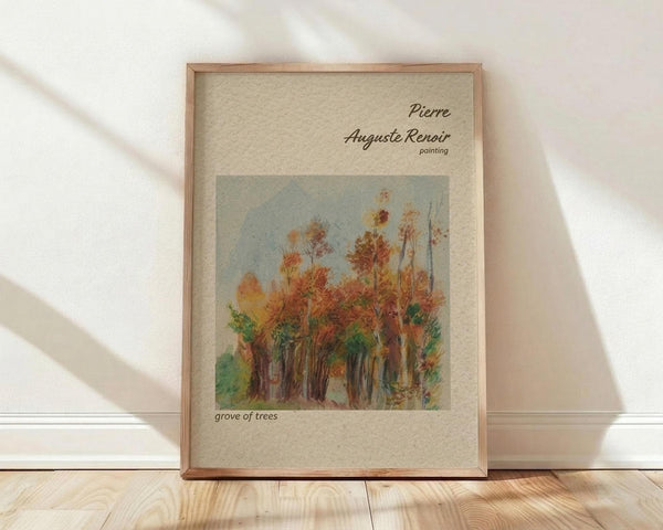 May include: Framed art print featuring Pierre-Auguste Renoir's impressionist painting of autumn trees with orange, red, and green foliage against a pale blue sky. The wooden-framed poster sits on light wood flooring against a white wall with soft natural lighting creating diagonal shadows across the scene.