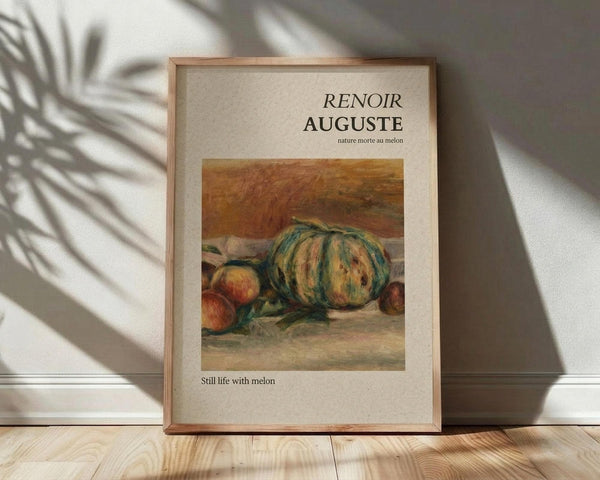 May include: Framed art print featuring Renoir's still life painting of a striped green and yellow melon with peaches on a table, displayed on light wooden floor against white wall with palm leaf shadows cast across the scene.