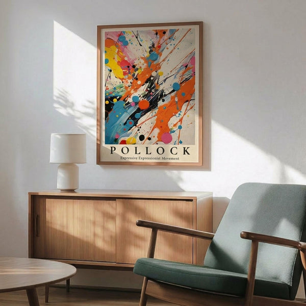 May include: Framed abstract expressionist poster with vibrant paint splatters in orange, blue, yellow, and black against cream background, displayed above mid-century modern wooden credenza with white ceramic lamp. Sage green upholstered chair with wooden arms sits nearby in sunlit room with white walls and wooden flooring.