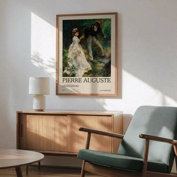 May include: Framed art print featuring Renoir's impressionist painting of a woman in flowing white dress walking with a man in dark clothing through a lush green garden setting. The poster hangs above a modern wooden sideboard with white ceramic lamp, next to a mint green upholstered armchair with wooden frame. Warm sunlight streams across white walls creating geometric shadows in this contemporary living room scene.
