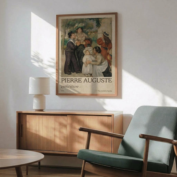 May include: Framed exhibition poster featuring a classical painting of a family group with adults and children in period dress, displayed above a wooden sideboard with white ceramic lamp. Mint green mid-century modern armchair with wooden arms sits nearby in bright, naturally lit room with white walls and hardwood floors.