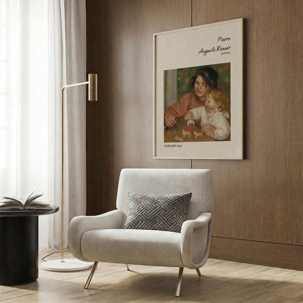 May include: Framed Renoir reproduction poster showing woman in brown dress with blonde child holding toys, displayed on wood paneled wall above beige upholstered armchair with geometric patterned pillow. Modern reading corner with brass floor lamp and dark side table with open book. Warm neutral tones throughout contemporary interior setting.