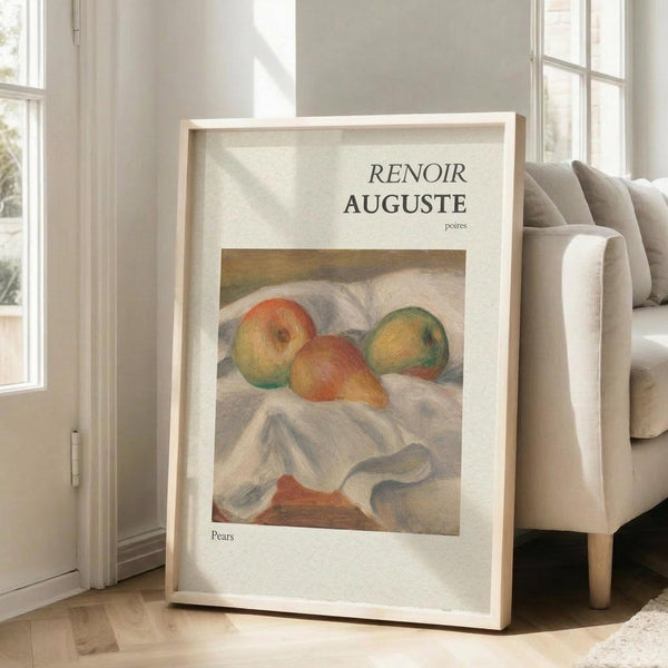May include: Framed art print leaning against white wall next to beige upholstered chair in bright room with large windows. Print features soft-toned still life painting of three pears on draped white fabric, displayed in light wood frame with white matting and museum-style text layout.