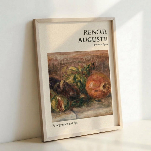 May include: A framed art print leaning against a white wall on a light surface. The print features a still life painting of pomegranates and figs in warm earth tones with rich reds, greens, and browns. Text reads "RENOIR AUGUSTE" at the top with "grenade et figues" below, and "Pomegranate and figs" at the bottom. The simple wooden frame has a natural light wood finish and white matting surrounds the artwork.