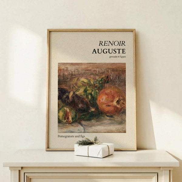 May include: Framed art print featuring Renoir's still life painting of pomegranates and figs in warm orange, yellow and green tones, displayed on a light wood shelf against a cream wall. Small white gift box with evergreen sprig sits beside the natural wood frame.