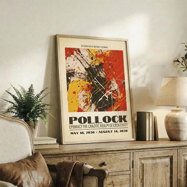 May include: Abstract art poster with vibrant red, yellow, and black paint splatters in Pollock style, displayed in light wooden frame on rustic sideboard. Room setting features fern plant, cream ceramic vase, stacked books, and brown leather chair. Poster shows chaotic brushstrokes and drip painting technique with exhibition text below artwork.
