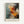 May include: Abstract expressionist art poster in light wood frame mounted on white wall. Dynamic paint splatters and brushstrokes in vibrant orange, red, black, white, and blue-gray creating explosive movement across canvas. Bold "POLLOCK" text with "Expressive Expressionist Movement" subtitle at bottom. Energetic composition shows dripping paint technique with scattered dots and gestural marks radiating from central burst.