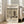 May include: Framed vintage Japanese woodblock print showing snow-covered temple with five-story pagoda and figure with umbrella, displayed in light wooden frame leaning against white wall next to beige upholstered chair in bright modern living room with large windows