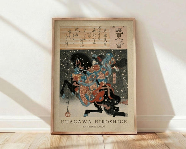 May include: Framed Japanese woodblock print artwork displayed against white wall on wooden floor. Shows warrior figure in ornate blue and orange robes with flowing fabric, wielding sword amid swirling black shapes and white dots suggesting snow or stars. Traditional calligraphy appears above colorful illustration on aged paper background. Natural wood frame with simple border surrounds vintage-style reproduction print.