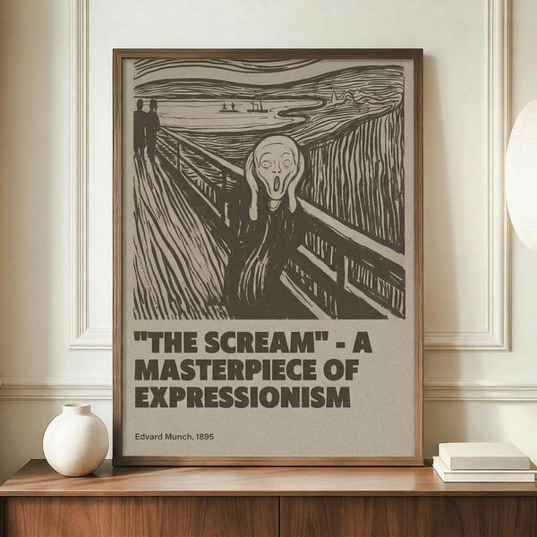 May include: Framed poster featuring Edvard Munch's The Scream artwork in black and white with bold text below reading "THE SCREAM - A MASTERPIECE OF EXPRESSIONISM" and "Edvard Munch, 1895". The wooden-framed print leans against a white paneled wall on a wooden sideboard next to a round white ceramic vase and stack of books.