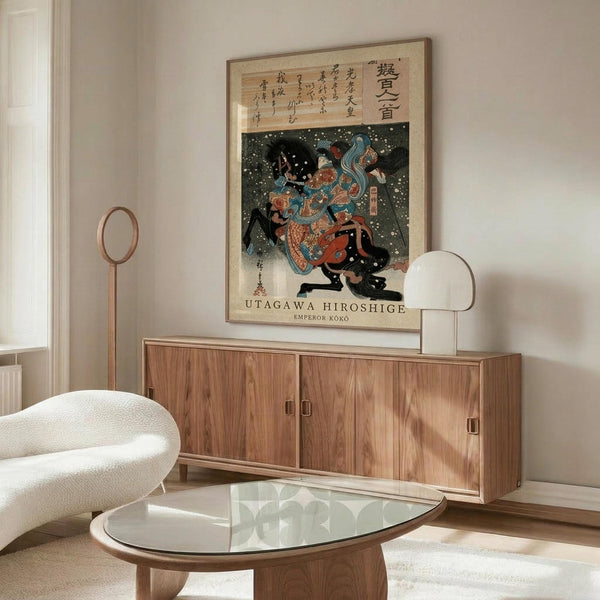 May include: Japanese ukiyo-e woodblock print artwork displayed above a mid-century modern wooden sideboard in a minimalist living room. The colorful print features a warrior figure in traditional dress against a dark snowy background with Japanese text. Scene includes a white curved chair, glass-top oval coffee table, and modern floor lamp with warm lighting on white walls.