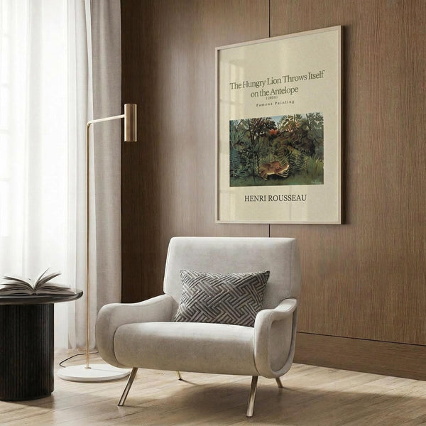 May include: Henri Rousseau jungle painting poster displayed on wood paneled wall above beige upholstered armchair with geometric patterned pillow. Modern reading corner with brass floor lamp, dark side table with open book, and white curtains. Poster shows lush green tropical foliage with hidden lion hunting scene in cream colored frame.