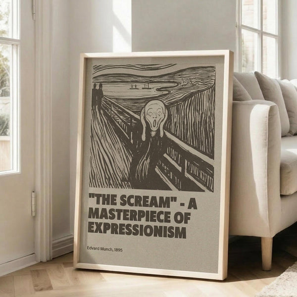 May include: Framed poster of Edvard Munch's The Scream artwork displayed in bright modern living room. Black and white reproduction shows iconic figure with hands on face on wooden bridge, with swirling sky background. Text below reads "THE SCREAM - A MASTERPIECE OF EXPRESSIONISM" and "Edvard Munch, 1895". Light wood frame leans against white wall next to beige upholstered sofa with wooden legs. Natural sunlight streams through tall windows.