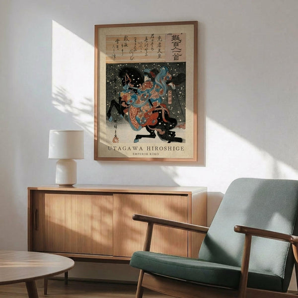 May include: Japanese woodblock print artwork displayed in modern living room with wooden sideboard, mint green upholstered chair, and white table lamp. The framed poster shows a figure in colorful robes against dark snowy background with Japanese text above. Warm sunlight streams across white walls creating geometric shadows. Mid-century modern furniture in natural wood tones complements the traditional art style.