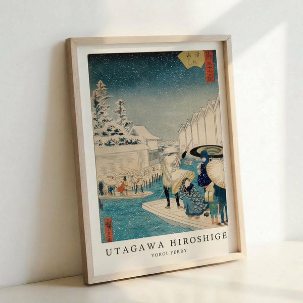 May include: A framed Japanese woodblock print showing a snowy winter scene with figures on a ferry boat crossing blue water. The artwork features a starry night sky, snow-covered buildings and trees, and people with traditional umbrellas. The print has Japanese text in the upper corner and is displayed in a light wooden frame against a white wall.