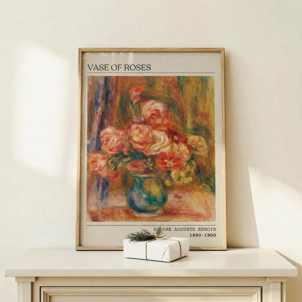 May include: Framed art print of an impressionist painting showing pink and coral roses in a blue-green vase, displayed on a light wood console table with a small white wrapped gift. The poster features warm, painterly brushstrokes in a gold frame against a cream wall.