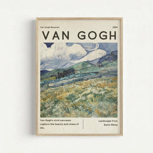May include: Framed museum-style poster featuring Van Gogh's swirling landscape painting with golden wheat fields, rolling green hills, and dramatic blue sky with white clouds. The poster displays "VAN GOGH" in large letters at top, "Van Gogh Museum 1889" header, the colorful artwork in center, and descriptive text below reading "Van Gogh's vivid canvases capture the beauty and chaos of life" and "Landscape from Saint-Rémy". Light wood frame against white wall
