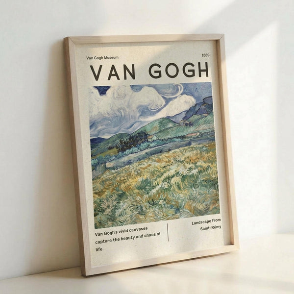 May include: Framed Van Gogh landscape poster leaning against white wall. The print features swirling brushstrokes in blues, greens, and yellows depicting rolling hills under a dramatic cloudy sky. Text reads "VAN GOGH" at top with "Van Gogh Museum 1889" and "Landscape from Saint-Rémy" below the artwork. Light wood frame surrounds cream-colored poster with museum-style layout and descriptive text about Van Gogh's vivid canvases.