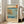 May include: Framed Japanese woodblock print featuring a coastal scene with turquoise waters, rocky cliffs, small boats, and Mount Fuji in the distance. The artwork displays traditional ukiyo-e style with muted earth tones and blue hues, positioned on light wooden floors next to a beige sofa in a bright room with white walls and large windows.