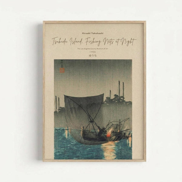 Framed Japanese woodblock print reproduction showing fishing boats with large nets at twilight on blue water. The vintage-style artwork features muted colors with a beige sky, dark silhouetted boats, and traditional calligraphy in the upper left corner. Displayed in a light wooden frame against a white wall, with museum attribution text above the image.