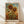 May include: Framed sunflower artwork in warm golden and brown tones leaning against white wall on light wood floor. The botanical illustration shows tall sunflowers with detailed petals and leaves against blue sky with sun. Natural wood frame surrounds the vintage-style print with artist attribution at bottom.