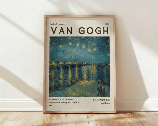May include: Framed poster print featuring Van Gogh's night scene with swirling blue sky filled with golden stars above a river reflecting yellow lights, two figures on shoreline in foreground. Museum-style layout with artist name, date 1888, and descriptive text below artwork. Natural wood frame displayed on light wooden floor against white wall with soft shadows.
