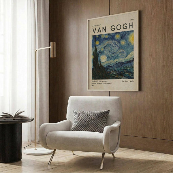May include: Van Gogh Starry Night museum poster displayed above a cream armchair with geometric pillow in modern living room. Poster shows swirling blue night sky with yellow stars and moon over village silhouette. Wood paneled wall, brass floor lamp, open book on dark side table, and beige curtains complete the sophisticated neutral interior scene.