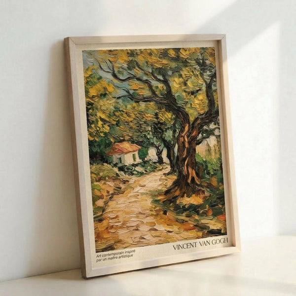 A framed art print featuring Van Gogh's distinctive thick brushstroke style depicting olive trees with gnarled, twisted trunks and golden-yellow foliage. A small white cottage with red roof sits along a winding dirt path in the background. The painting uses rich yellows, greens, and earth tones with Van Gogh's characteristic swirling texture. The print is displayed in a light wood frame against a white wall, with "VINCENT VAN GOGH" text visible at the bottom.