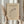 May include: Person in cream sweater holding framed abstract art print featuring curved black lines and geometric shapes on beige background. Natural lighting, dried pampas grass visible, neutral tones throughout scene. Wooden frame, minimalist home decor setting.