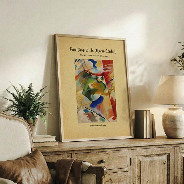 May include: Framed abstract art print with colorful geometric shapes in blues, reds, yellows and greens on beige background, displayed on rustic wooden sideboard alongside fern plant, ceramic vase, and stacked books in warm neutral living room setting with cream upholstered furniture