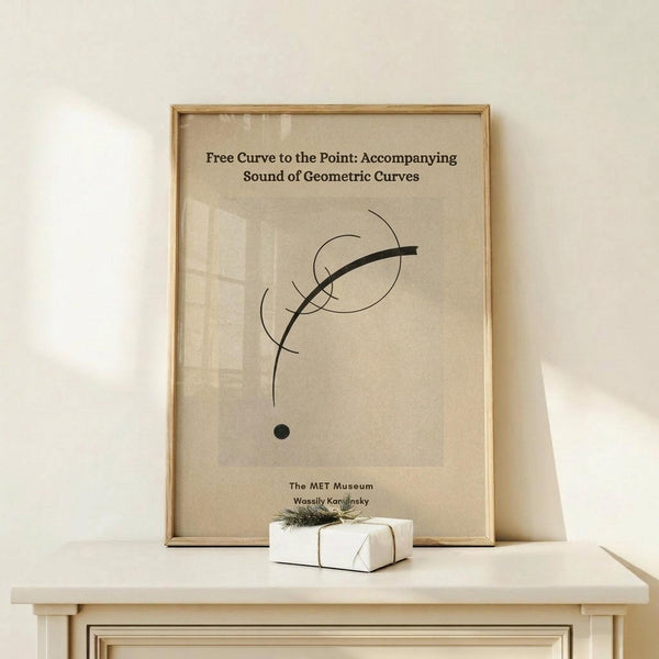 May include: Framed beige poster with abstract black curved lines and a circle, displayed on light wood surface with small wrapped gift box. Modern minimalist wall art in natural wood frame against cream wall with soft lighting and shadows.