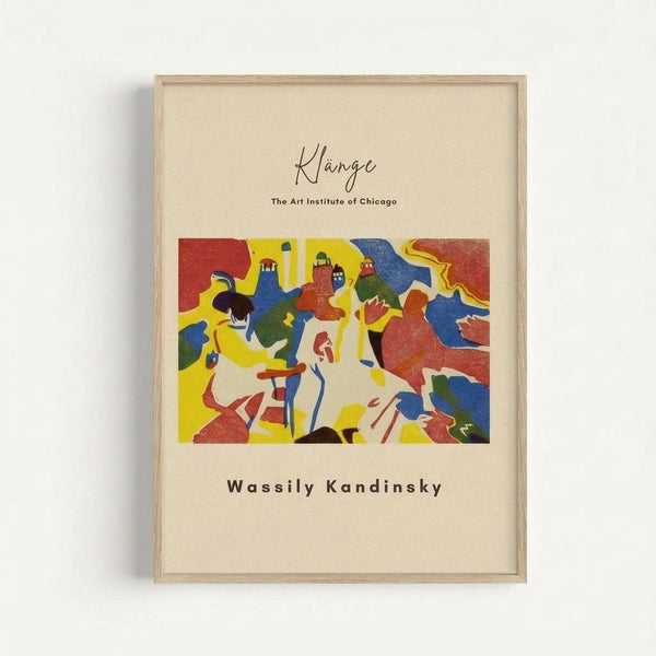 Framed abstract art print featuring vibrant geometric shapes and figures in bold colors including red, yellow, blue, and green. The artwork shows stylized human forms and architectural elements in Kandinsky's distinctive expressionist style. Text above reads "Klänge" and "The Art Institute of Chicago" with "Wassily Kandinsky" below the image. Light wood frame against cream-colored matting on white wall.