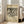 May include: Framed art print leaning against white wall next to beige armchair in bright living room. Print features black abstract linear artwork on cream background with museum-style text layout. Natural wood frame, approximately 2 feet tall, sits on light wooden floors with white baseboards and large windows visible.