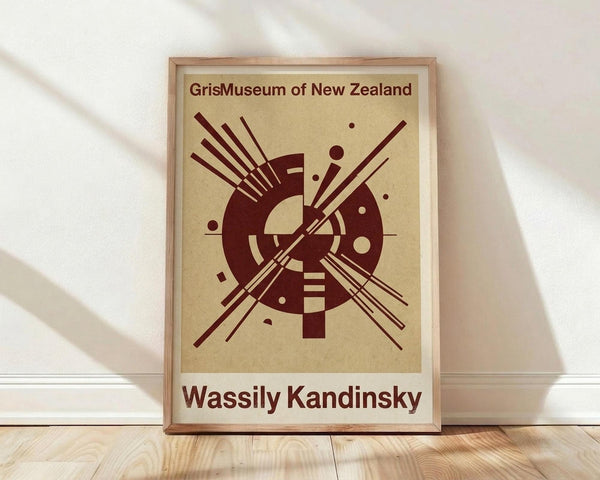 May include: Framed poster with abstract geometric design in dark red on cream background, featuring circular forms with radiating lines and scattered dots in modernist style, displayed in light wood frame against white wall on wooden floor with natural lighting