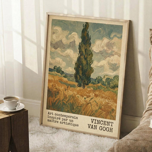 May include: Framed Van Gogh poster print featuring a tall dark cypress tree against swirling clouds and golden wheat field, displayed in a cozy room setting with natural light, white walls, wooden side table with coffee cup, and cream textured blanket nearby