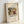 May include: Framed art print leaning against white wall showing Wassily Kandinsky's abstract painting with flowing organic shapes in earth tones, greens, and reds. The artwork features curved forms and dynamic brushstrokes typical of early abstract expressionism. Print is displayed in light wooden frame on textured cream paper with artist name and artwork title below the image.