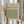 May include: Hands holding a framed vintage botanical print with green geometric diaper pattern design on beige background. Light wood frame, neutral room setting with dried pampas grass stems and soft natural lighting through curtains. Warm earth tones throughout.