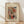 May include: Framed abstract watercolor artwork in wooden frame leaning against white wall on light wood floor. The painting features flowing organic shapes in red, orange, green, and blue with dynamic black lines and curves. Cream matting surrounds the colorful contemporary art piece. Natural lighting creates soft shadows across the minimal room setting.