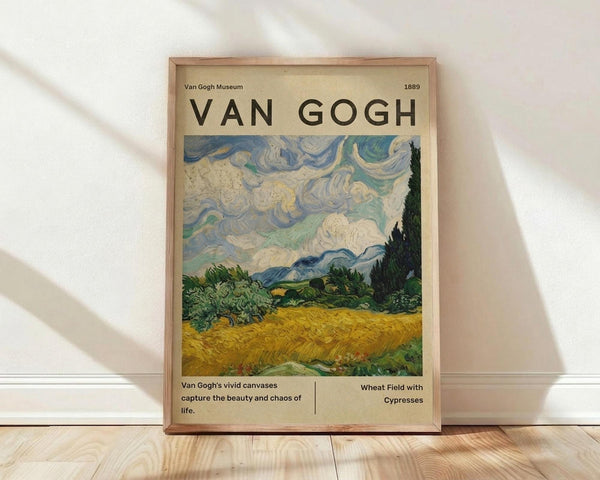 May include: Framed Van Gogh museum poster featuring "Wheat Field with Cypresses" painting with swirling blue and white clouds, golden wheat field, and dark cypress trees. Beige background with black text and 1889 date. Natural wood frame leaning against white wall on light wooden floor with soft window shadows.