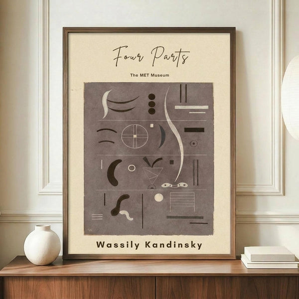 May include: Framed museum poster with abstract geometric shapes and lines in brown tones on cream background, displayed on wooden sideboard next to white ceramic vase and stacked books in elegant room with white wainscoting and beige walls