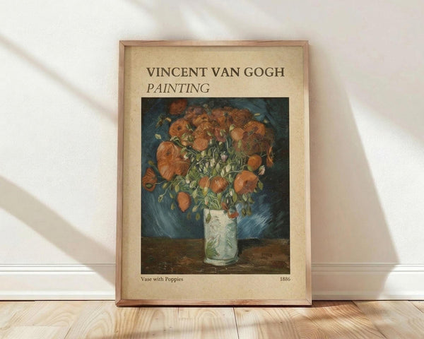 May include: Framed Van Gogh poster print leaning against white wall on wooden floor. Shows vibrant orange poppies in white vase against blue background. Cream-colored poster with brown text header and artwork details. Natural wood frame with thin profile. Soft natural lighting creates diagonal shadows across white textured wall.