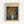 Framed art print featuring Van Gogh's floral still life painting with orange poppies in a white vase against a blue background. The print has cream-colored matting with black text reading "VINCENT VAN GOGH PAINTING" at the top and "Vase with Poppies 1886" at the bottom. Natural wood frame displayed against a white wall.
